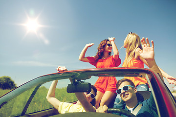 Image showing happy friends driving in cabriolet car