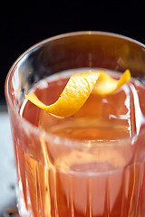 Image showing close up of glass with orange cocktail at bar