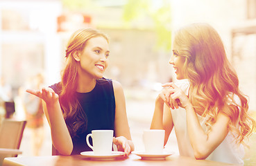 Image showing young women drinking coffee and talking at cafe