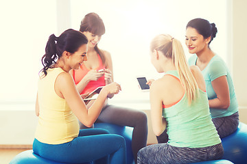 Image showing happy pregnant women with gadgets in gym