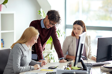 Image showing happy business team with calculator at office