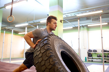 Image showing man doing strongman tire flip training in gym