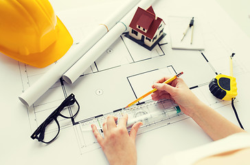 Image showing close up of hands with ruler measuring blueprint