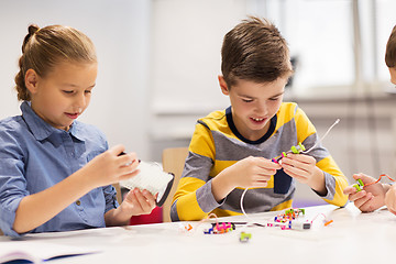 Image showing happy children building robots at robotics school