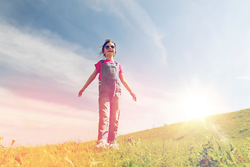 Image showing happy little girl over green field and blue sky