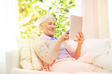 Image showing happy senior woman with tablet pc at home