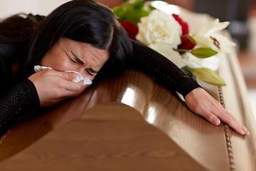 Image showing woman with coffin crying at funeral in church