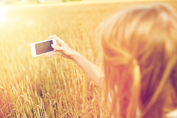 Image showing close up of girl with smartphone on cereal field