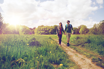 Image showing happy couple with backpacks hiking outdoors