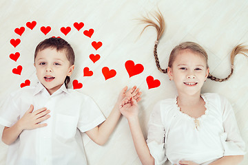 Image showing little boy and girl lying on the floor.