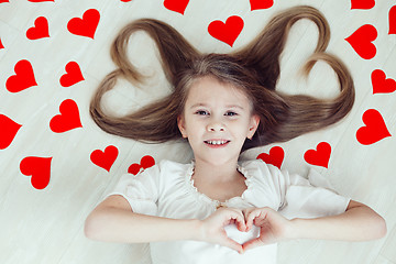 Image showing One little girl lying on the floor.