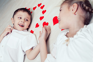 Image showing little boy and girl lying on the floor.