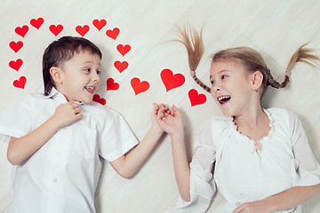 Image showing little boy and girl lying on the floor.