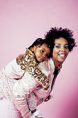 Image showing young pretty african-american mother with little cute daughter hugging, happy smiling on pink background, lifestyle modern people concept 