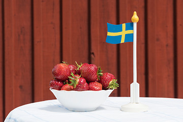 Image showing Bowl with fresh strawberries and a swedish flag