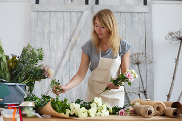 Image showing Young girl florist makes bouquet