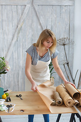 Image showing Young florist cutting paper wrapping