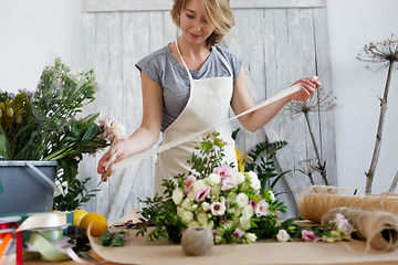 Image showing Florist with beautiful bouquet , ribbon,