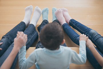 Image showing happy children which are sitting on the stairs in the house.