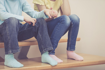 Image showing happy children which are sitting on the stairs in the house.