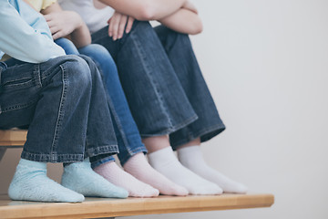 Image showing happy children which are sitting on the stairs in the house.