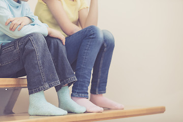 Image showing happy children which are sitting on the stairs in the house.