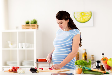 Image showing pregnant woman cooking vegetables at home