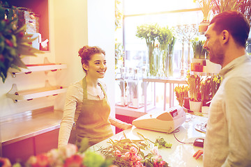 Image showing smiling florist woman and man at flower shop