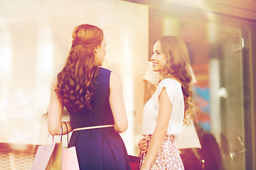 Image showing happy women with shopping bags at shop window