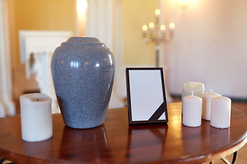 Image showing photo frame, cremation urn and candles in church