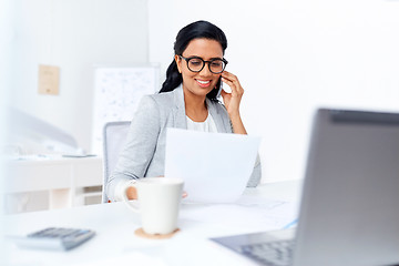 Image showing businesswoman calling on smartphone at office