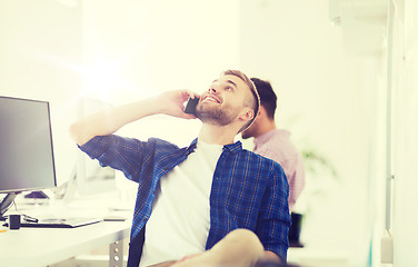 Image showing happy creative man calling on cellphone at office