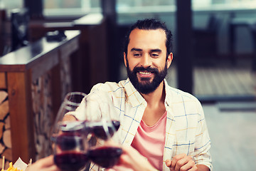 Image showing happy man clinking glass of wine at restaurant