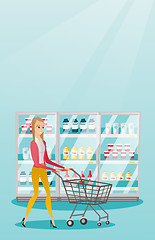 Image showing Young caucasian woman with supermarket trolley.