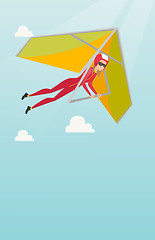 Image showing Young caucasian woman flying on hang-glider.