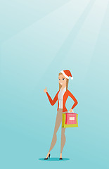 Image showing Woman in santa hat shopping for christmas gifts.