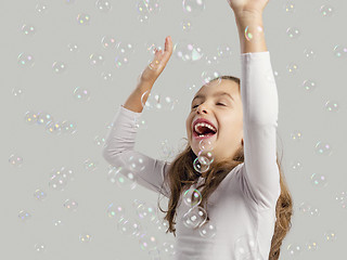 Image showing Girl playing with soap bubbles