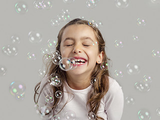 Image showing Girl playing with soap bubbles