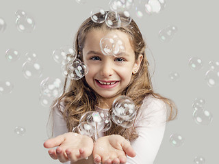 Image showing Girl playing with soap bubbles