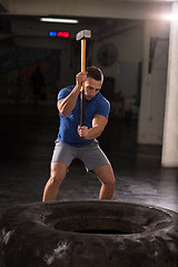 Image showing man workout with hammer and tractor tire