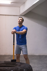 Image showing man workout with hammer and tractor tire