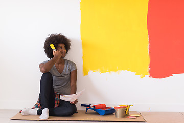 Image showing back female painter sitting on floor