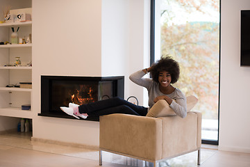 Image showing black woman in front of fireplace