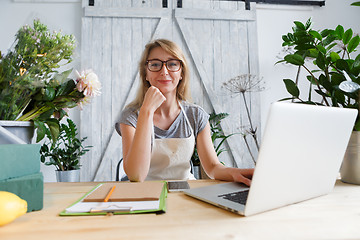 Image showing Florist girl sitting at table