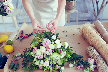 Image showing Woman makes composition of flowers