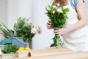 Image showing Young woman florist makes bouquet