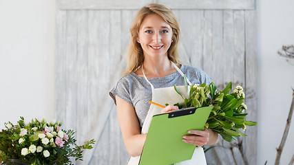 Image showing Florist woman writes down orders