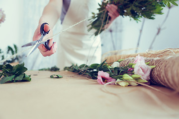 Image showing Woman florist makes beautiful bouquet