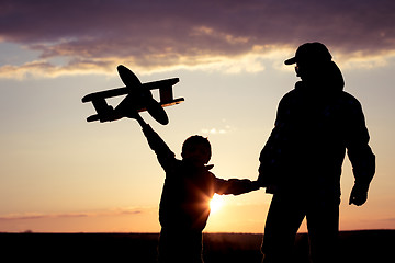 Image showing Father and son playing with cardboard toy airplane in the park a