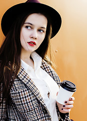 Image showing young pretty hipster girl student with coffee cup posing adorable smiling, lifestyle people concept outdoor 